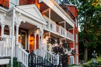a large red brick house with white railings at Niagara Grandview Boutique Hotel in Niagara Falls