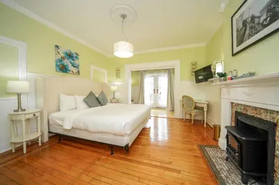 a bedroom with a white bed and a fireplace at Niagara Grandview Boutique Hotel in Niagara Falls