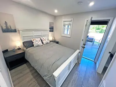 a bedroom with a bed and a door to a balcony at Luxe Home Near Limeridge - Sleeps 11 - Pool in Hamilton