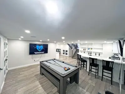 a living room with a pool table and a tv at Luxe Home Near Limeridge - Sleeps 11 - Pool in Hamilton