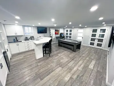 a large kitchen with white cabinets and a table at Luxe Home Near Limeridge - Sleeps 11 - Pool in Hamilton