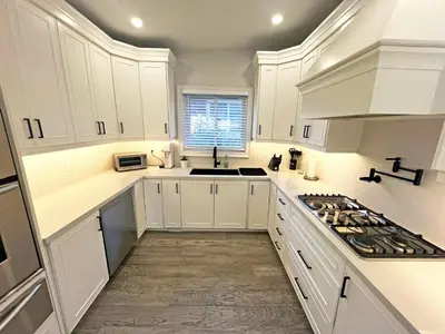 a white kitchen with white cabinets and a sink at Luxe Home Near Limeridge - Sleeps 11 - Pool in Hamilton