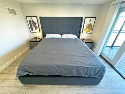 a large bed in a bedroom with two windows at Luxe Home Near Limeridge - Sleeps 11 - Pool in Hamilton