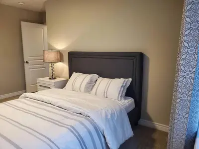 a bedroom with a bed with white sheets and a lamp at 4 BD Family Retreat - Basement not Included in Stratford