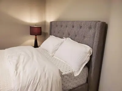 a bed with white sheets and pillows next to a lamp at 4 BD Family Retreat - Basement not Included in Stratford
