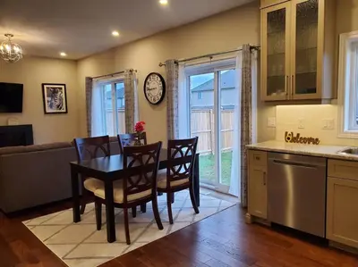 a kitchen with a table and chairs and a clock on the wall at 4 BD Family Retreat - Basement not Included in Stratford