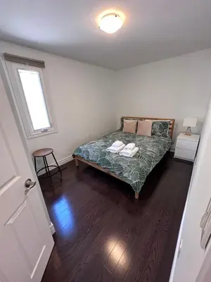 a bedroom with a bed in a room with a window at Toronto GREAT Located in Toronto