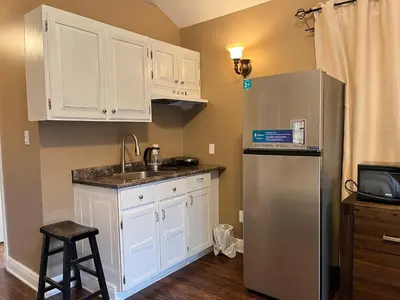 a kitchen with white cabinets and a stainless steel refrigerator at THE RED STAR room E in Niagara Falls