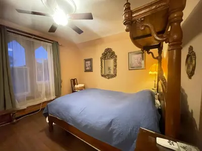 a bedroom with a bed and a ceiling fan at THE RED STAR ROOM B in Niagara Falls