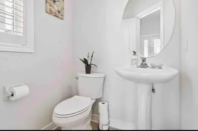 a white bathroom with a toilet and a sink at The cozy corner House in the Richmond Hill in Richmond Hill
