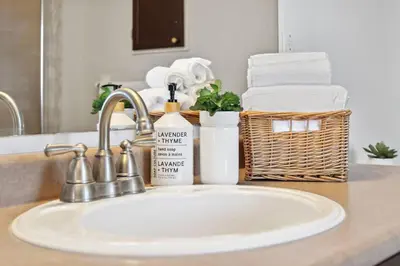 a bathroom counter with a sink and a basket of towels at The cozy corner House in the Richmond Hill in Richmond Hill