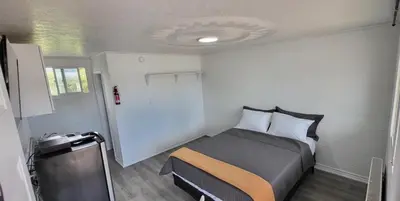 a small bedroom with a bed and a window at Happyland Inn in Orillia