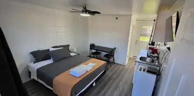 a bedroom with a bed and a desk with a sink at Happyland Inn in Orillia