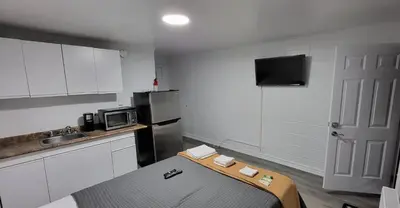 a small kitchen with a bed and a microwave at Happyland Inn in Orillia