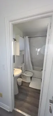 a bathroom with a toilet and a sink at Happyland Inn in Orillia