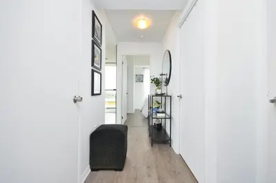 a hallway of a home with white walls and wood floors at The Splendid - Luxury 1BR Uptown Toronto in Toronto