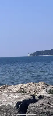 a large body of water with a lighthouse in the distance at Cottage in Crystal Beach in Fort Erie