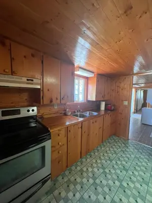 a kitchen with wooden cabinets and a stove top oven at Cottage in Crystal Beach in Fort Erie