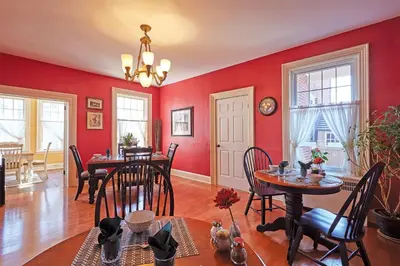 a dining room with red walls and tables and chairs at The Inn on Bay in Gravenhurst
