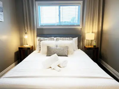 a bedroom with a large white bed with two towels on it at The Capri Suite in Old South London in London