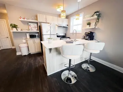 a kitchen with a counter and two stools in it at The Capri Suite in Old South London in London