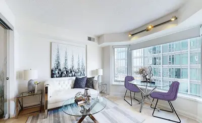 a living room with a bed and a glass table at University of Toronto UTSG Suites in Toronto