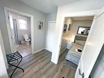 a bedroom with a bed and a bathroom with a toilet at Hamilton Haven - Smart Tech and BBQ Oasis - Pool in Hamilton