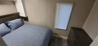 a small bedroom with a bed and a window at Moira Lake Cottages in Madoc
