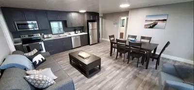 a living room with a couch and a table and a kitchen at Moira Lake Cottages in Madoc