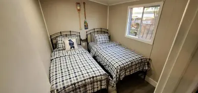 two beds in a corner of a room at Moira Lake Cottages in Madoc