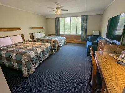 a hotel room with two beds and a couch at Mariner motor hotel in Collingwood