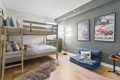 a bedroom with two bunk beds and a blue couch at Luxury 2 Level Mountain Walk Condo Sauna Jacuzzi Walk to Village in Blue Mountains