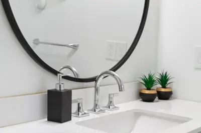a bathroom sink with two faucets and a mirror at Luxury 2 Level Mountain Walk Condo Sauna Jacuzzi Walk to Village in Blue Mountains