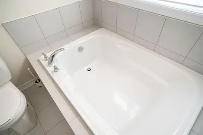 a white bath tub in a bathroom with a toilet at BRAND NEW home minutes from Niagara Falls. in Thorold