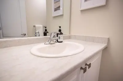 a bathroom with a white sink and a mirror at BRAND NEW home minutes from Niagara Falls. in Thorold