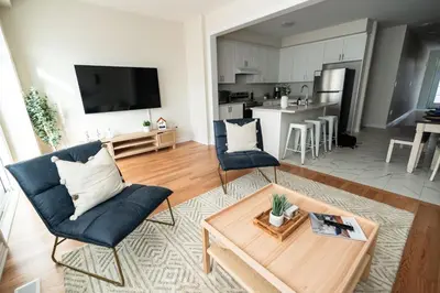 a living room with a couch and a table at BRAND NEW home minutes from Niagara Falls. in Thorold