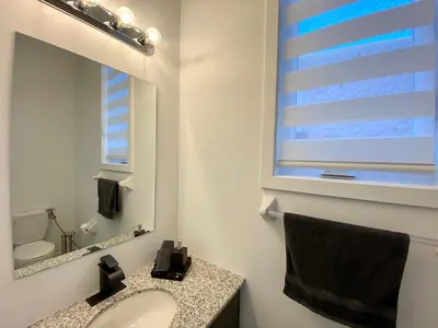 a bathroom with a sink and a mirror at 3 Bedroom Well-designed Townhouse in Whitby in Whitby