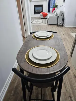 a wooden table with plates on it in a living room at Poolside entire lower level apt in Whitby