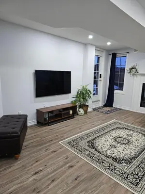 a living room with a flat screen tv on a wall at Poolside entire lower level apt in Whitby