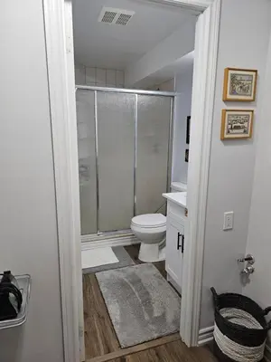 a bathroom with a shower and a toilet at Poolside entire lower level apt in Whitby