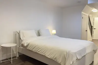 a white bedroom with a white bed and a stool at Stylish Home in Prime Location North of Toronto in Richmond Hill