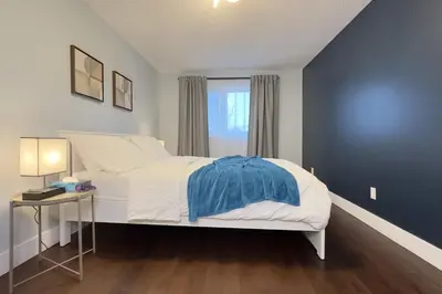 a bedroom with a white bed and a blue wall at Stylish Home in Prime Location North of Toronto in Richmond Hill