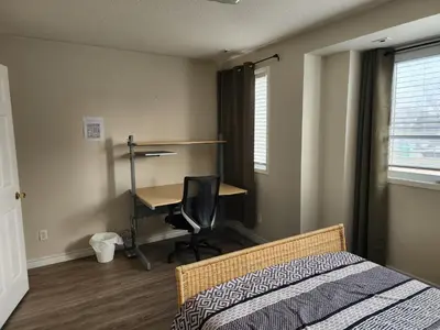 a bedroom with a bed and a desk with a computer at Scarborough Townhouse in Toronto