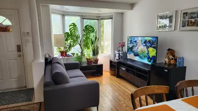 a living room with a couch and a flat screen tv at Scarborough Townhouse in Toronto