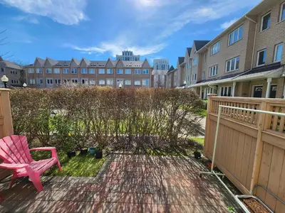 a pink chair sitting on a patio with a fence at Scarborough Townhouse in Toronto