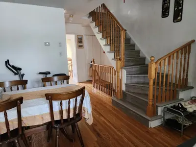 a room with a staircase and a table and chairs at Scarborough Townhouse in Toronto