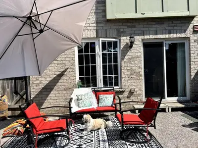 a dog laying on a rug next to chairs and an umbrella at Luxury Home In Castlemore Brampton in Brampton