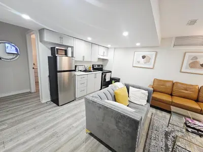 a living room with a couch and a kitchen at Friendly Neighborhood Garden Ave Suite in Brantford