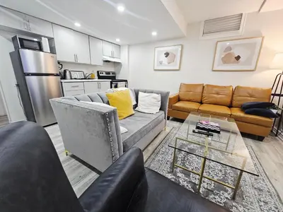 a living room with a couch and a table at Friendly Neighborhood Garden Ave Suite in Brantford