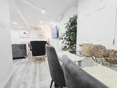 a living room with chairs and a table at Friendly Neighborhood Garden Ave Suite in Brantford